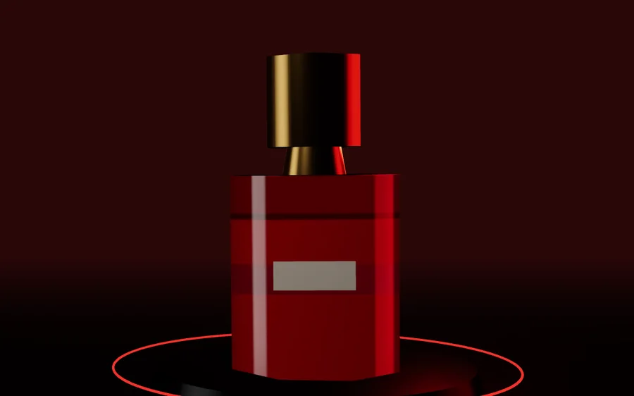 Glass perfume bottle with gold cap on a dark pedestal